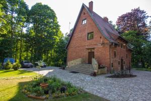 an old brick house with a garden in front of it at Willa Alkor in Drzeńsko