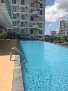 a swimming pool in front of a tall building at Lustra Studio in Davao City