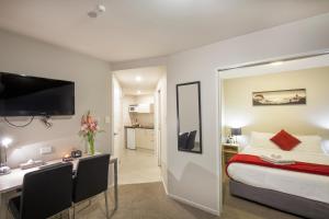 una camera con letto e scrivania e una camera di Vita Nova Motel a Christchurch
