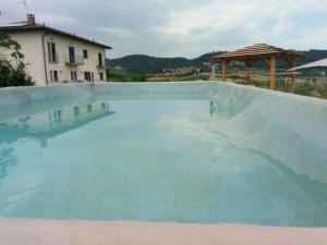 una gran piscina de agua frente a una casa en La Casa Di Baba', en Alfiano Natta