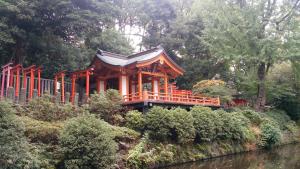 eine orangefarbene Pagode in einem Garten neben einem Fluss in der Unterkunft Namio Apartment 201 in Tokio