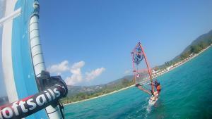 a man is windsurfing on the water on a boat at Castro Sunset Stories in Neos Marmaras