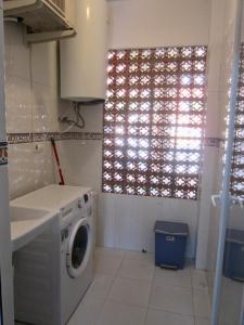 een wasmachine in een keuken met een raam bij Riviera Golf apartment in Mijas Costa