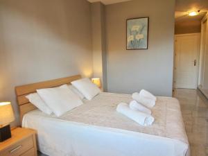 een slaapkamer met een bed met handdoeken erop bij Riviera Golf apartment in Mijas Costa
