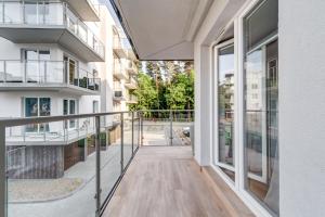 balkon budynku ze szklanymi drzwiami w obiekcie Skandynawia Lesne Tarasy w Dziwnówku