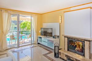 a living room with a fireplace and a television at Villa Europa in Heringsdorf