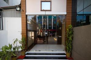 帕拉克卡德Hotel Kapilavasthu的玻璃入口,进入种植盆栽植物的建筑
