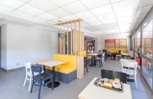 a dining area with tables and chairs in a restaurant at B&B HOTEL CHAMBERY La Cassine in Chambéry