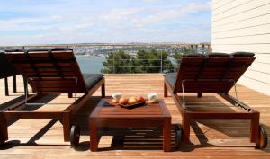 two chairs and a bowl of fruit on a deck at Quinta Tagus in Costa da Caparica