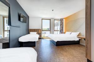 シャトネ・マラブリーにあるB&B HOTEL Paris Sud Chatenay Malabryのベッド2台とデスクが備わるホテルルームです。