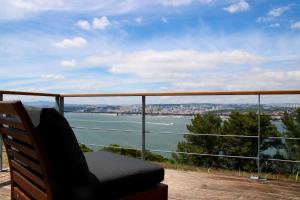 a chair on a balcony with a view of the water at Quinta Tagus in Costa da Caparica