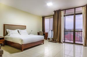 a bedroom with a bed and a large window at Igar Plaza Hotel in Jinja