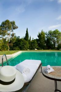 a pool with a bed and a table and towels at Son Gener Hotel Spa in Son Servera