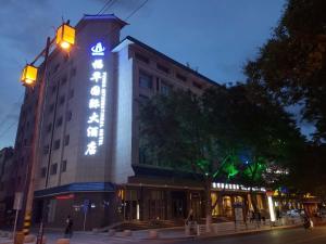 a building with a lit up sign on the side of it at Fu Hua International Hotel Dunhuang in Dunhuang