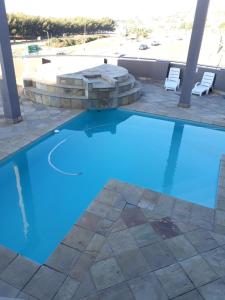 a swimming pool with a fire pit and blue water at Nautica flat 401 in Mossel Bay
