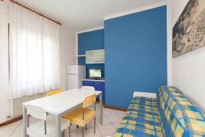 Habitación con mesa, sillas y pared azul. en Villa Valentina, en Lido di Jesolo