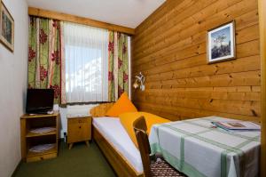 a hotel room with a bed and a television at Garni Ferwall in Galtür