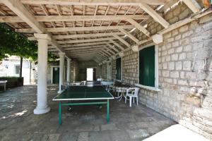 ヘルツェグ・ノヴィにあるGuest House Sagaのレンガの壁のパティオ(卓球台付)
