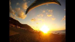 a person flying a kite on the beach at sunset at Appartamento fronte mare San vito lo capo in San Vito lo Capo