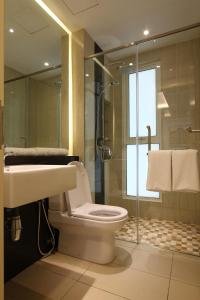 a bathroom with a toilet and a glass shower at The Shore Residence Apartment in Melaka