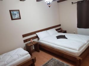 a bedroom with a bed and a nightstand and a bed sidx sidx at Cabana Vânătorilor din Valiug in Văliug