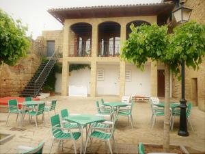 un patio avec des tables et des chaises en face d'un bâtiment dans l'établissement Hospedería Sádaba, à Sádaba