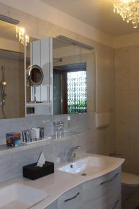 a white bathroom with a sink and a mirror at Villa Falkner in Tirolo