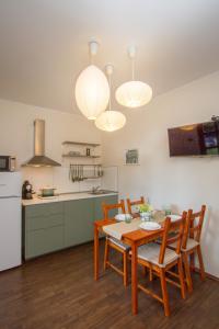 cocina y comedor con mesa y sillas en Green Residence Élményközpont Velence, en Velence