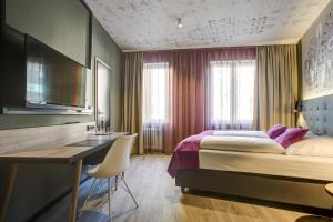 a hotel room with a bed and a desk and a desk at Central Hotel am Dom - Köln City in Cologne