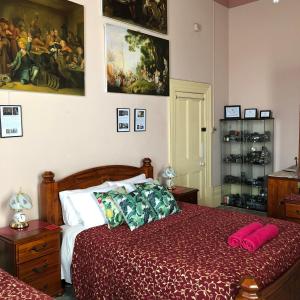 a bedroom with a bed with a red comforter at Albany Foreshore Guest House in Albany