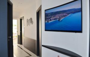 a flat screen tv hanging on a wall in a hallway at Centurio luxury rooms in Tropea