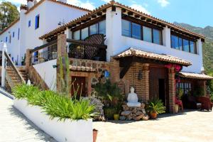 a large white house with a statue in front of it at Hotel Rural Los Jarales in Istán +36 photos