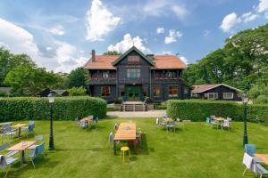 una casa grande con mesas y sillas delante de ella en Stayokay Hostel Gorssel - Deventer, en Gorssel