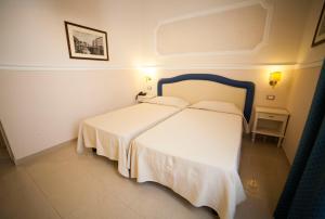 a bedroom with a white bed in a room at Hotel Gran Duca in Livorno