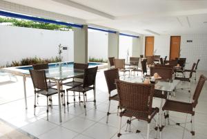 a dining room with tables and chairs and windows at Pousada Costa Marina in Fortaleza