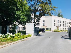 an empty street in front of a white building at Green GardenHotel in Raszyn