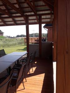 a long table and chairs on a wooden deck at Dom nad Rozlewiskiem in Zamość