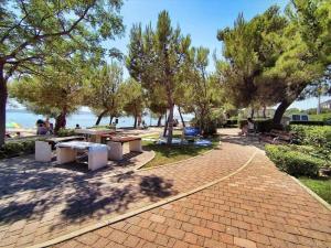 a park with picnic tables and trees and the water at Apartment Red Rose in Kaštela +21 photos