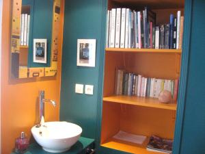 a bathroom with a sink and a book shelf with books at Chez Catie in Quintin