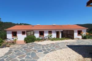 una casa con una entrada de piedra delante de ella en Vida Pura Apartments en Odeceixe