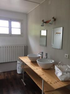 un bagno con due lavandini su un bancone in legno di Gites les Grandes Gouttes a Le Syndicat