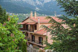 a house with a balcony and mountains in the background at Archontiko Christodoulou in Vronteró