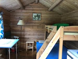 a room with a bunk bed and a table in a cabin at Tommerneset Camping in Innhavet