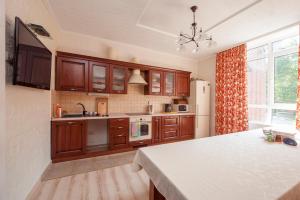 a kitchen with wooden cabinets and a white counter top at Villa Provans in Tatariv