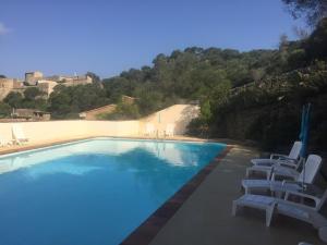 - une piscine bordée de chaises longues blanches dans l'établissement Hostellerie Provencale, à Port-Cros