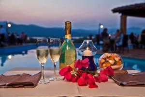 a table with two glasses of wine and flowers at Residence Stella Di Gallura in Porto Rotondo