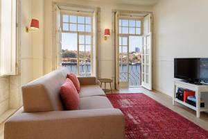 a living room with a couch and a television at Oporto Home - River Front in Porto