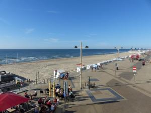 a beach with a group of people and the ocean at studio Zeedijk Emperador in Middelkerke