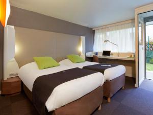 A bed or beds in a room at Campanile Villejust - za Courtaboeuf