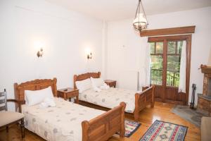 a bedroom with two beds and a fireplace at Archontiko Christodoulou in Vronteró